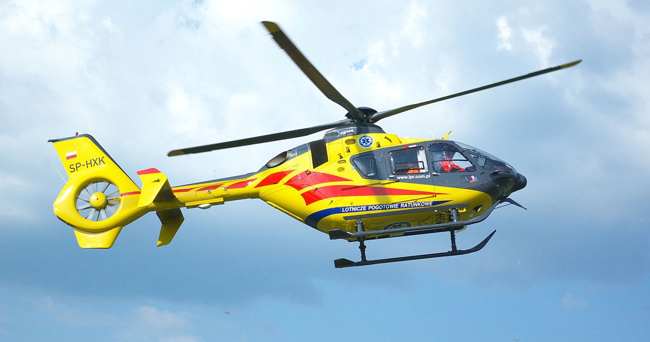 Helikopter Lotniczego Pogotowia Ratunkowego lądujący obok skoczni narciarskiej w Szczyrku, ze służbami ratunkowymi w pobliżu.