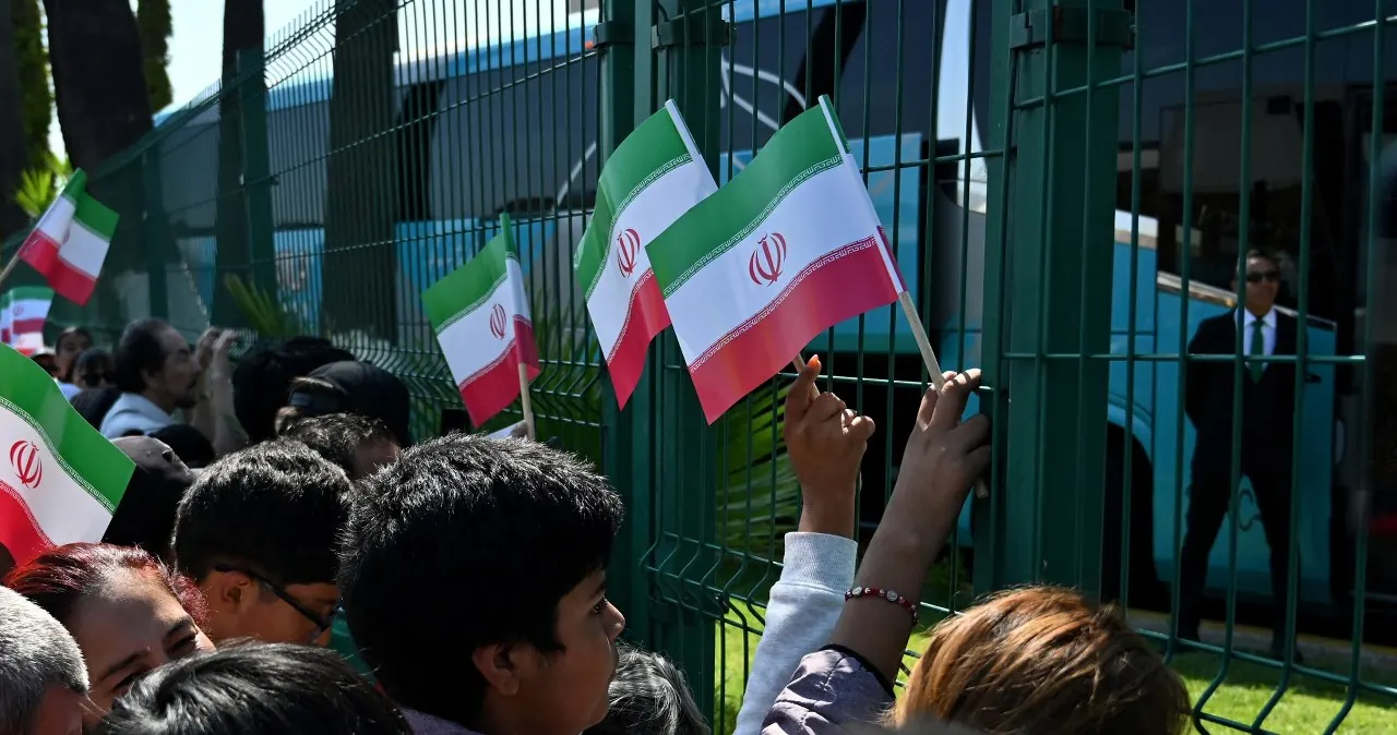Protestujący ludzie z flagami Iranu, USA i Izraela przed stadionem SoFi w Inglewood.