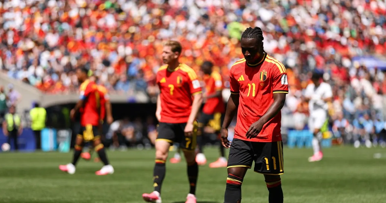 Jeremy Doku w koszulce reprezentacji Belgii, biegnie z piłką na boisku.