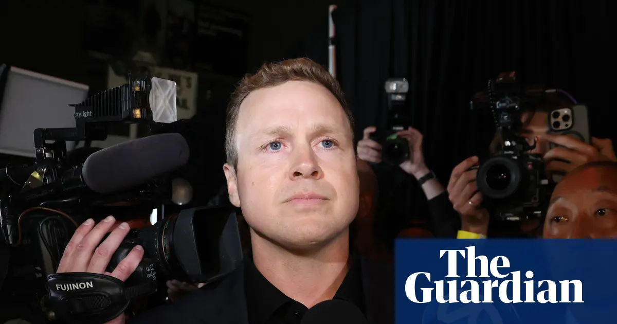 Spencer Pratt przemawiający do mediów przed restauracją Don Antonio's w Los Angeles, w tle widoczne budynki miejskie.