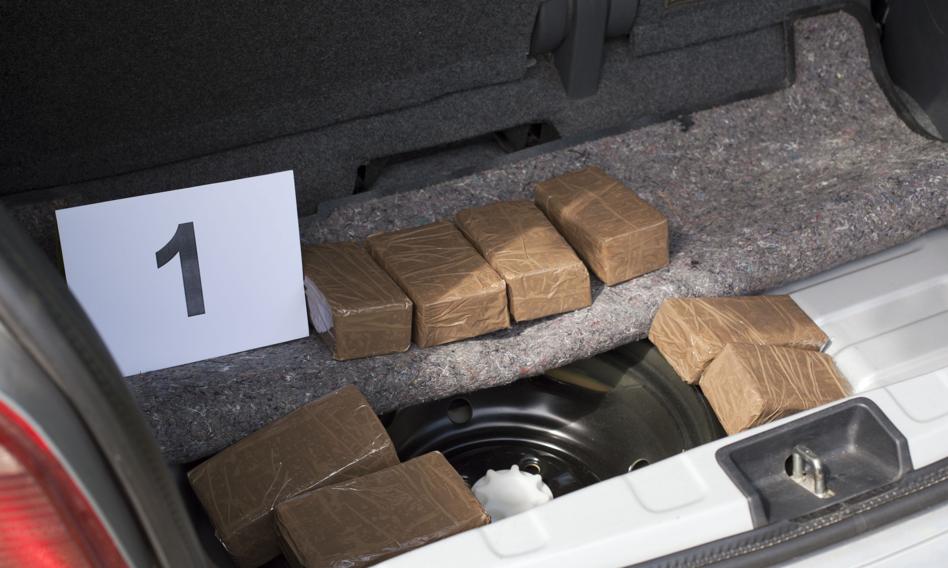 Policjanci zabezpieczają paczki z narkotykami przy paczkomacie.