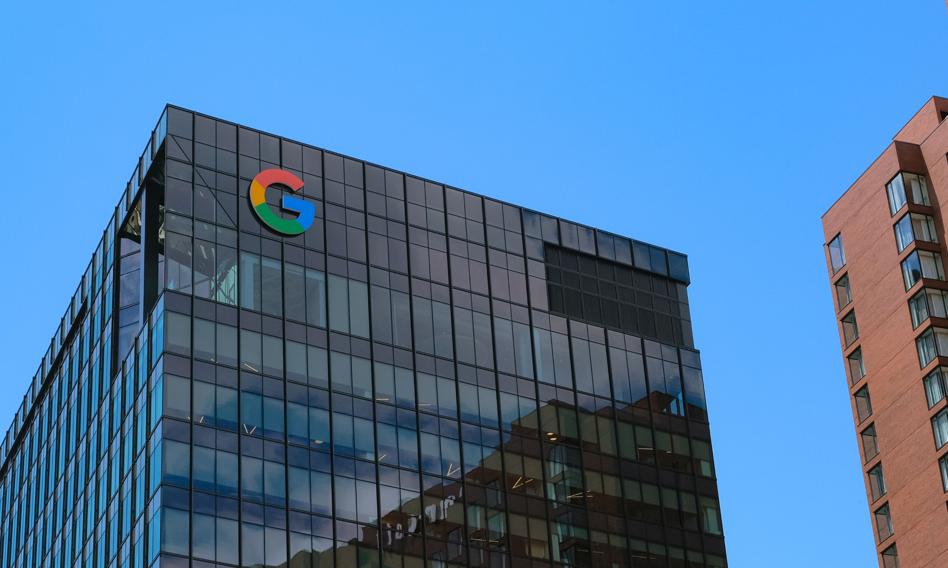 Nowoczesne wnętrze biura Google w Krakowie z pracującymi ludźmi i laptopami