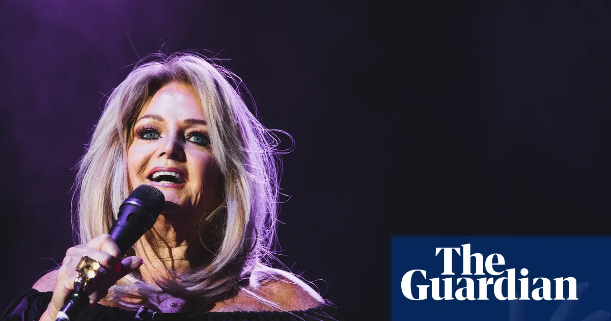 Bonnie Tyler, piosenkarka, uśmiechnięta na scenie podczas występu.