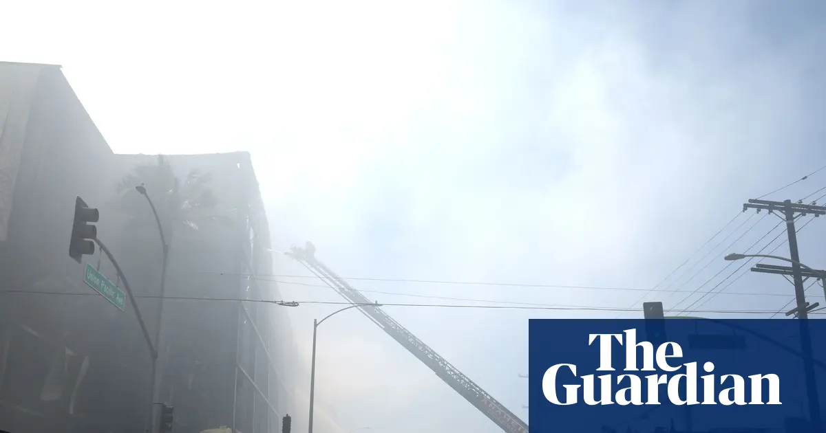 Strażacy walczący z ogromnym pożarem magazynu żywności mrożonej w Boyle Heights, Los Angeles, dym unoszący się nad budynkiem.