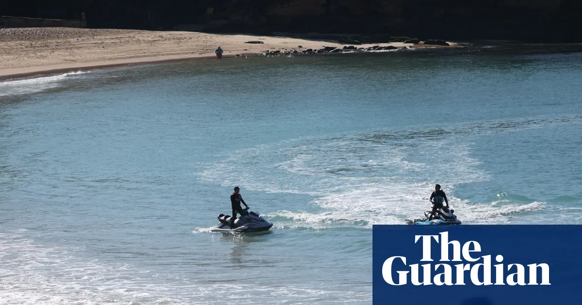 Widok na zamkniętą plażę Coogee w Sydney po ataku rekina, z widocznymi służbami ratunkowymi w tle.