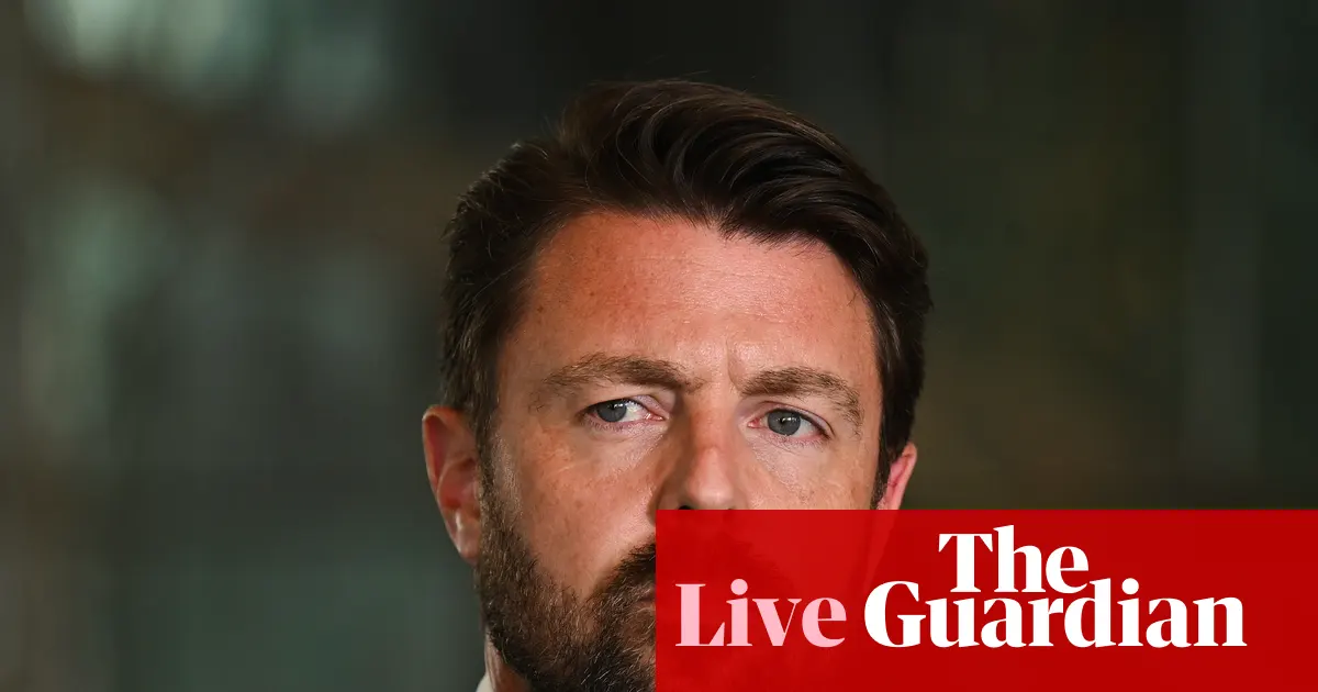 Senator Jonathon Duniam przemawia w australijskim parlamencie, obok grafika przedstawiająca płuca i symbol walki z rakiem.