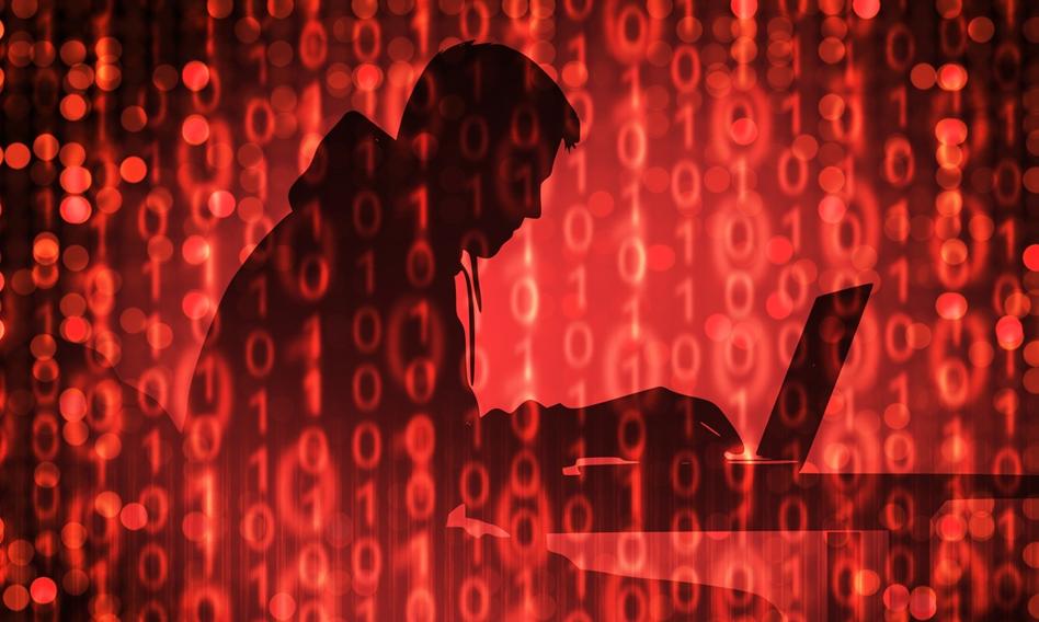 Zdjęcie przedstawiające kartę studencką leżącą na klawiaturze komputera, obok której widoczny jest symbol zagrożenia cybernetycznego, symbolizujące wyciek danych z uczelni.