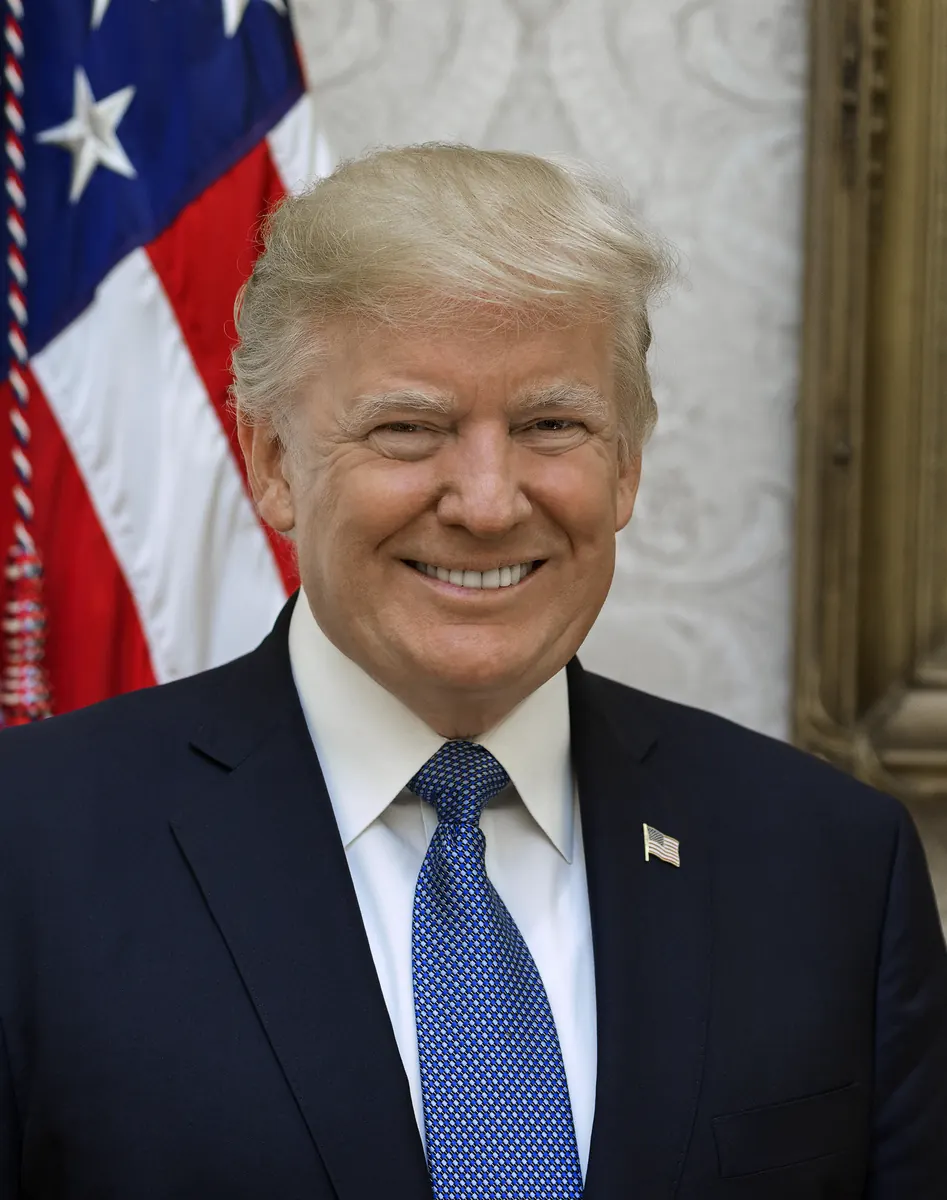 Donald Trump przemawiający, w tle flagi USA i Iranu, symbolizujące stosunki handlowe i dyplomatyczne.