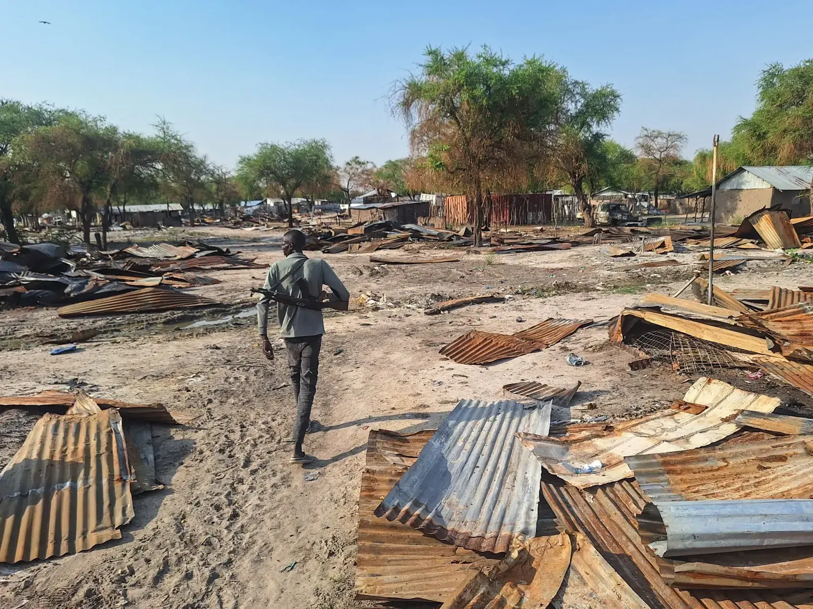 Zrujnowany budynek szpitala w Lankien, Sudan Południowy, z widocznym kraterem po eksplozji i zniszczonym dachem.