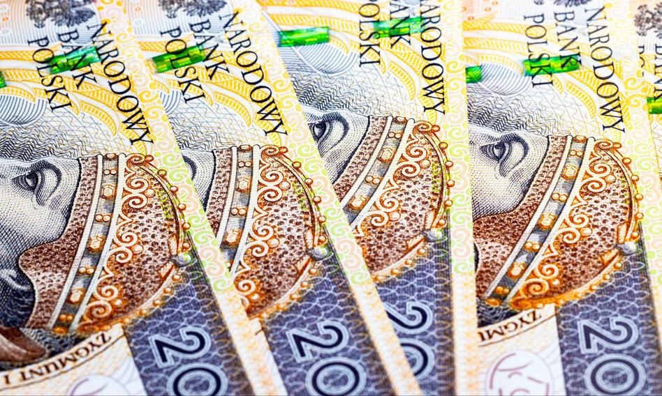Przedsiębiorca przeglądający oferty bankowe na tablecie, z wykresami i danymi finansowymi w tle