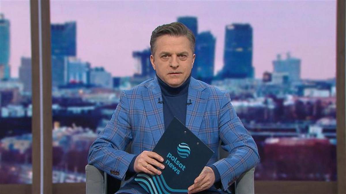Bogdan Rymanowski prowadzący debatę polityczną z sześcioma gośćmi w studiu telewizyjnym