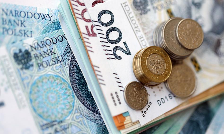 Małżeństwo przeglądające dokumenty finansowe i kalkulator, symbolizujące analizę ofert kredytów konsolidacyjnych.