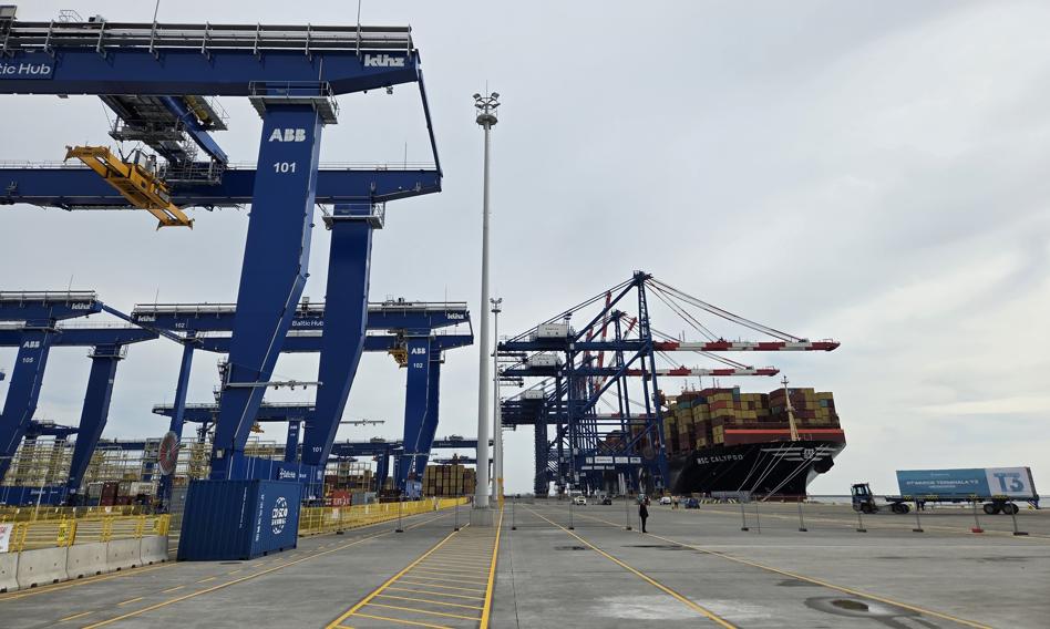 Widok na terminal kontenerowy Baltic Hub w Gdańsku z widocznymi suwnicami i kontenerami, w tle statki.