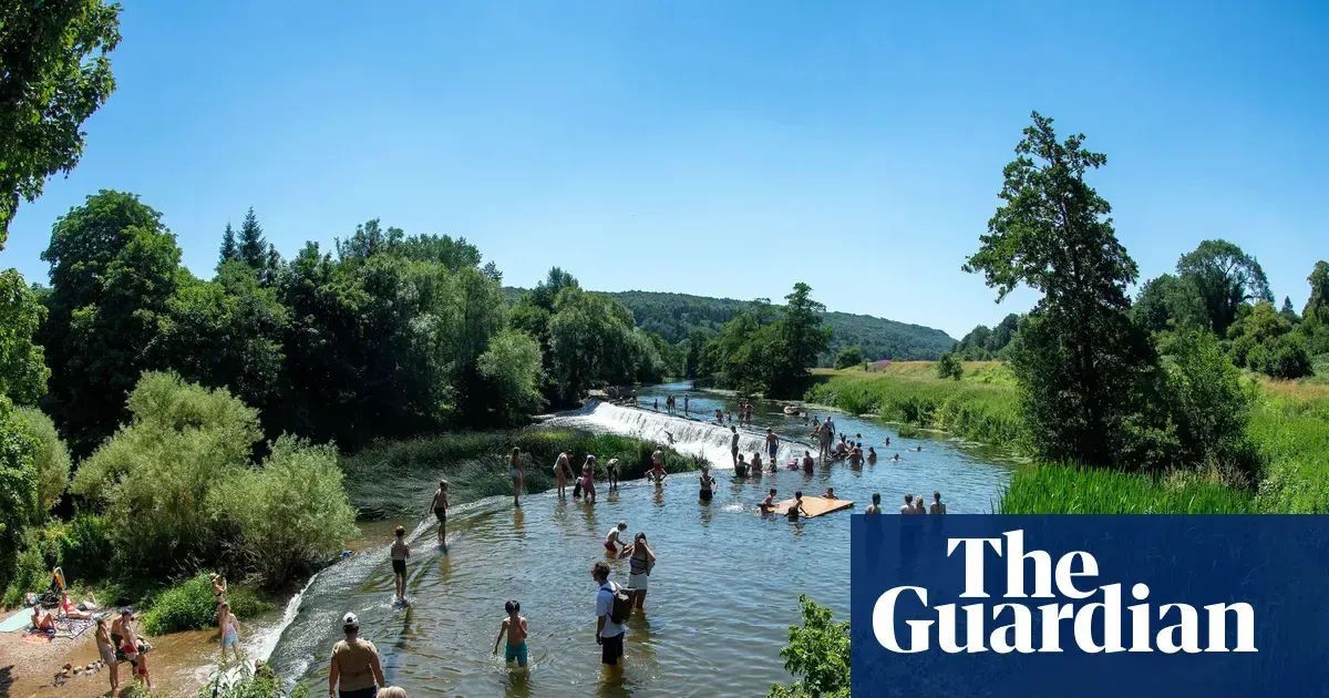 Osoby szukające ochłody nad rzeką Avon w Bath w Anglii podczas letnich upałów
