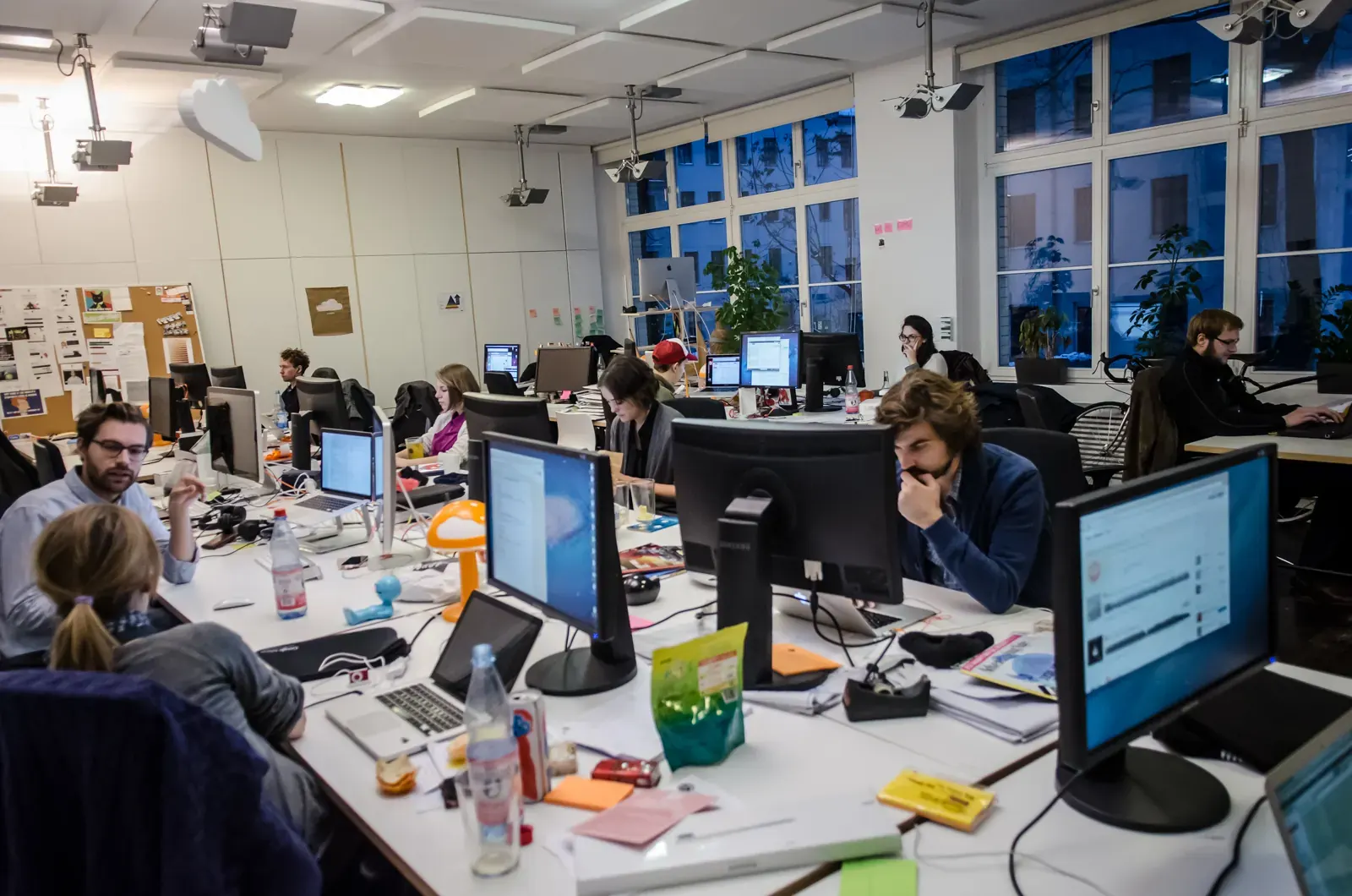Młodzi przedsiębiorcy omawiają plany biznesowe, symbolizujące rozwój start-upów i inwestycje venture capital w Polsce.