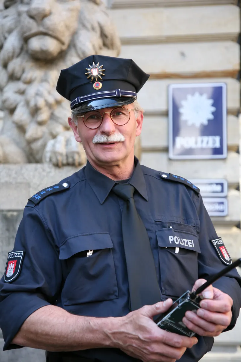 Radiowóz policyjny na tle budynku sądu, symbolizujący decyzję o areszcie dla napastnika na funkcjonariuszy CBZC.