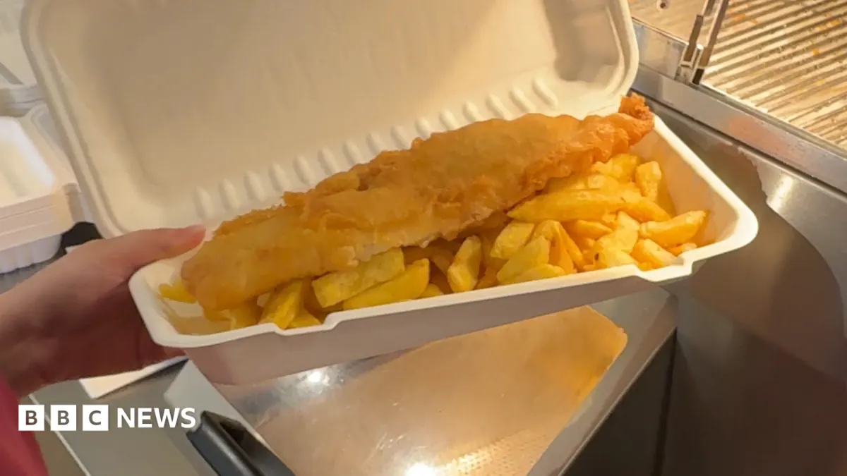 Zdjęcie porcji smażonej ryby z frytkami, typowego dania typu fast food.