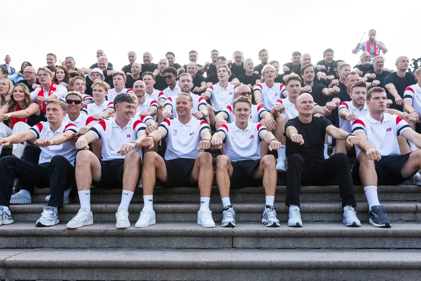 Zdjęcie tłumu przed Pałacem Królewskim w Oslo, z widocznym księciem Haakonem, który pozdrawia kibiców po powrocie reprezentacji Norwegii w piłce nożnej z Mistrzostw Świata.