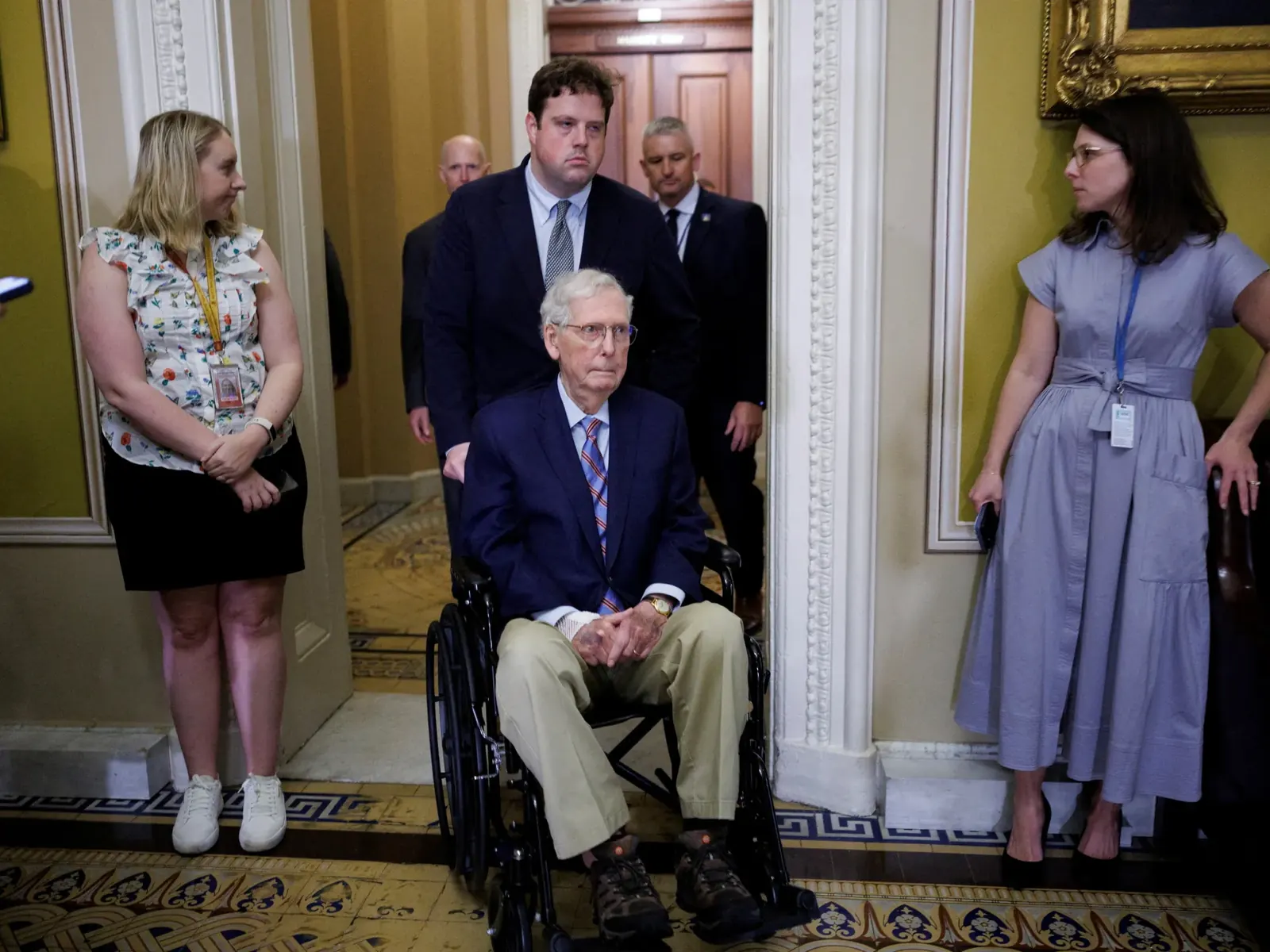 Senator Mitch McConnell uśmiecha się, siedząc obok swojej żony Elaine Chao.