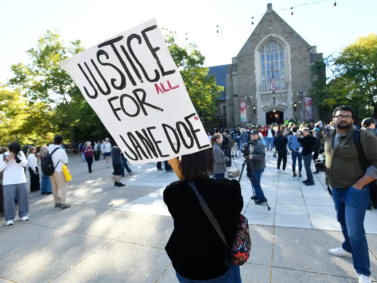 Uszkodzone szklane drzwi Day Hall na Cornell University z protestacyjnymi napisami na ścianach